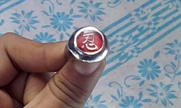 a ring with a red seal and gold "忍" emblem