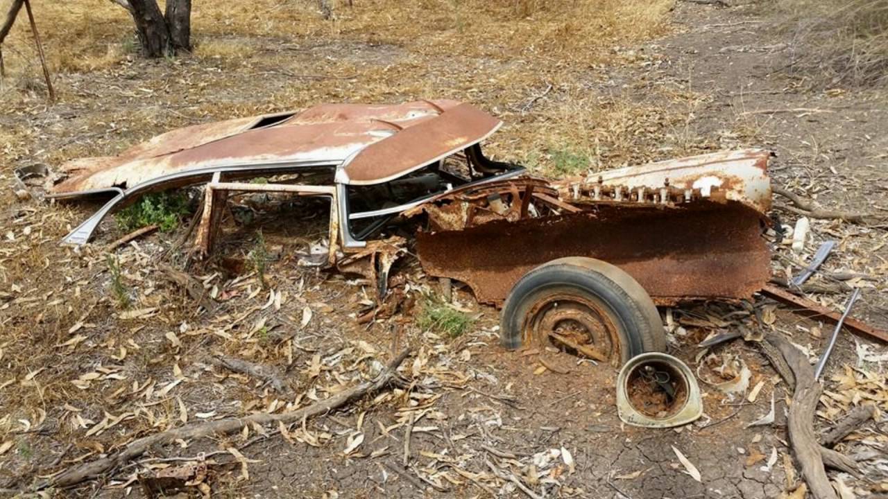 Carro velho enferrujado aos pedaços semienterrado