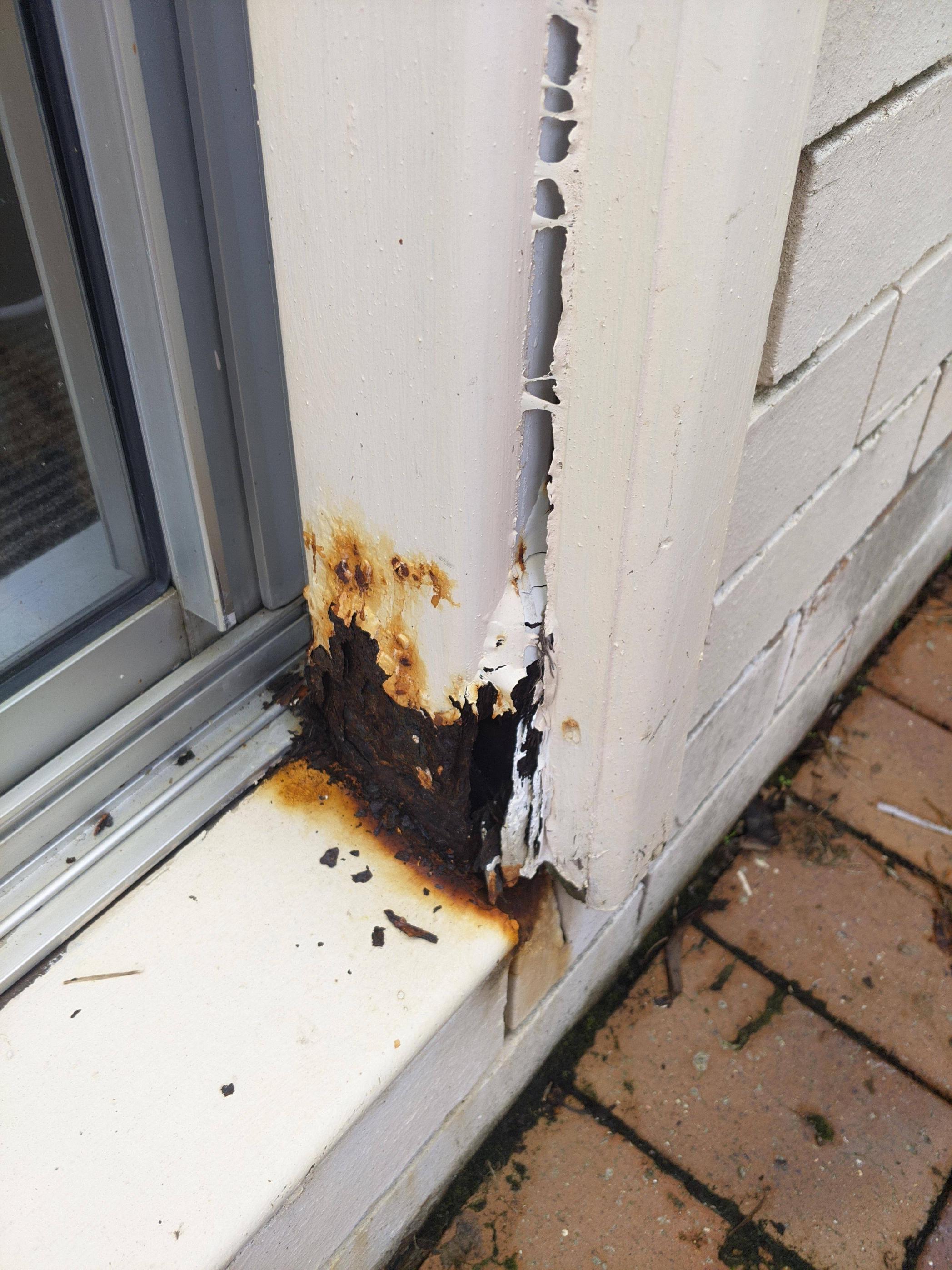 badly rusted metal post next to doorway