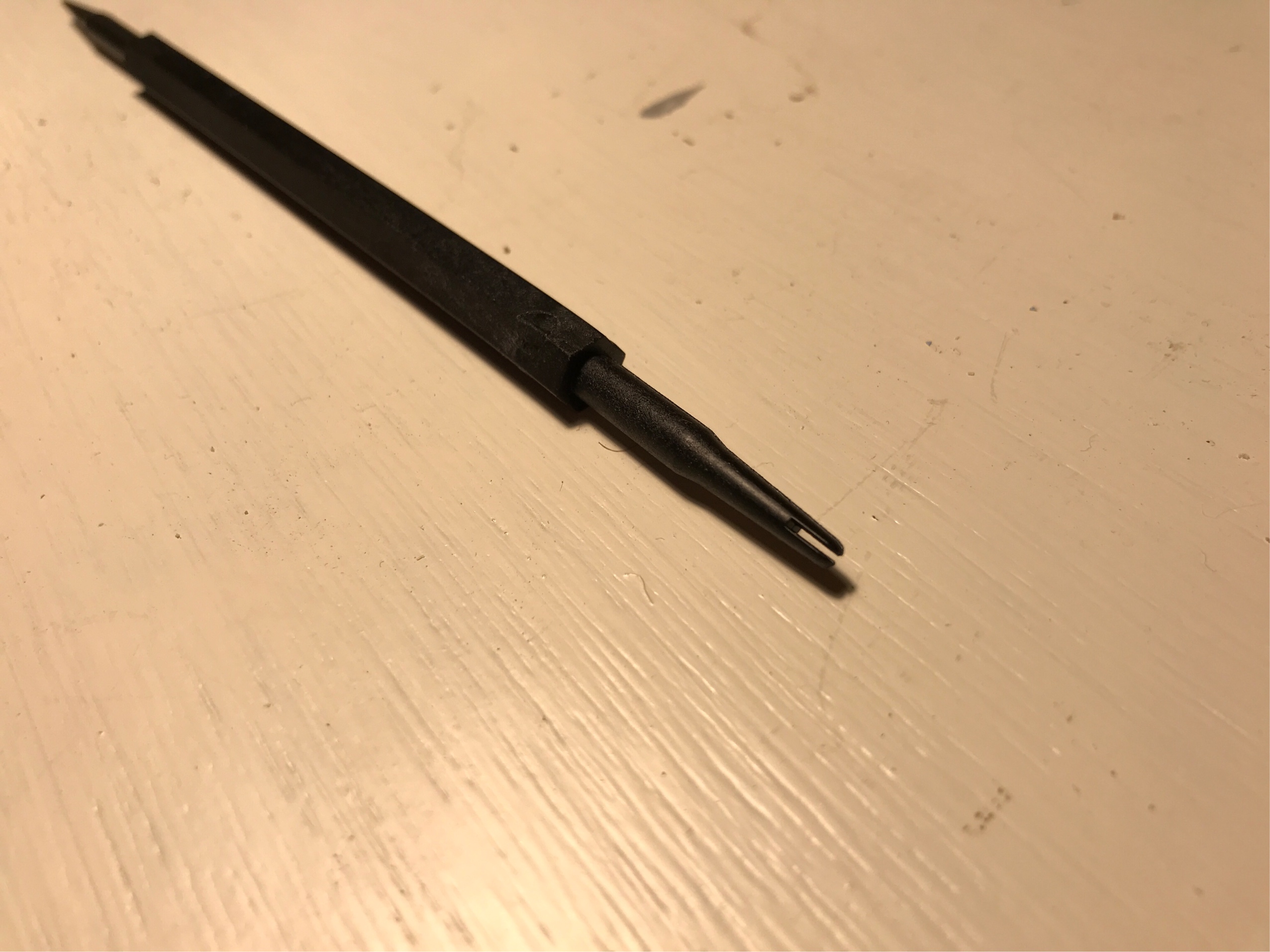 A third picture of the same tool, focused on the other end. The shaft has a similar conical shape, but a slot cuts through the blunted end, like a slotted screw.