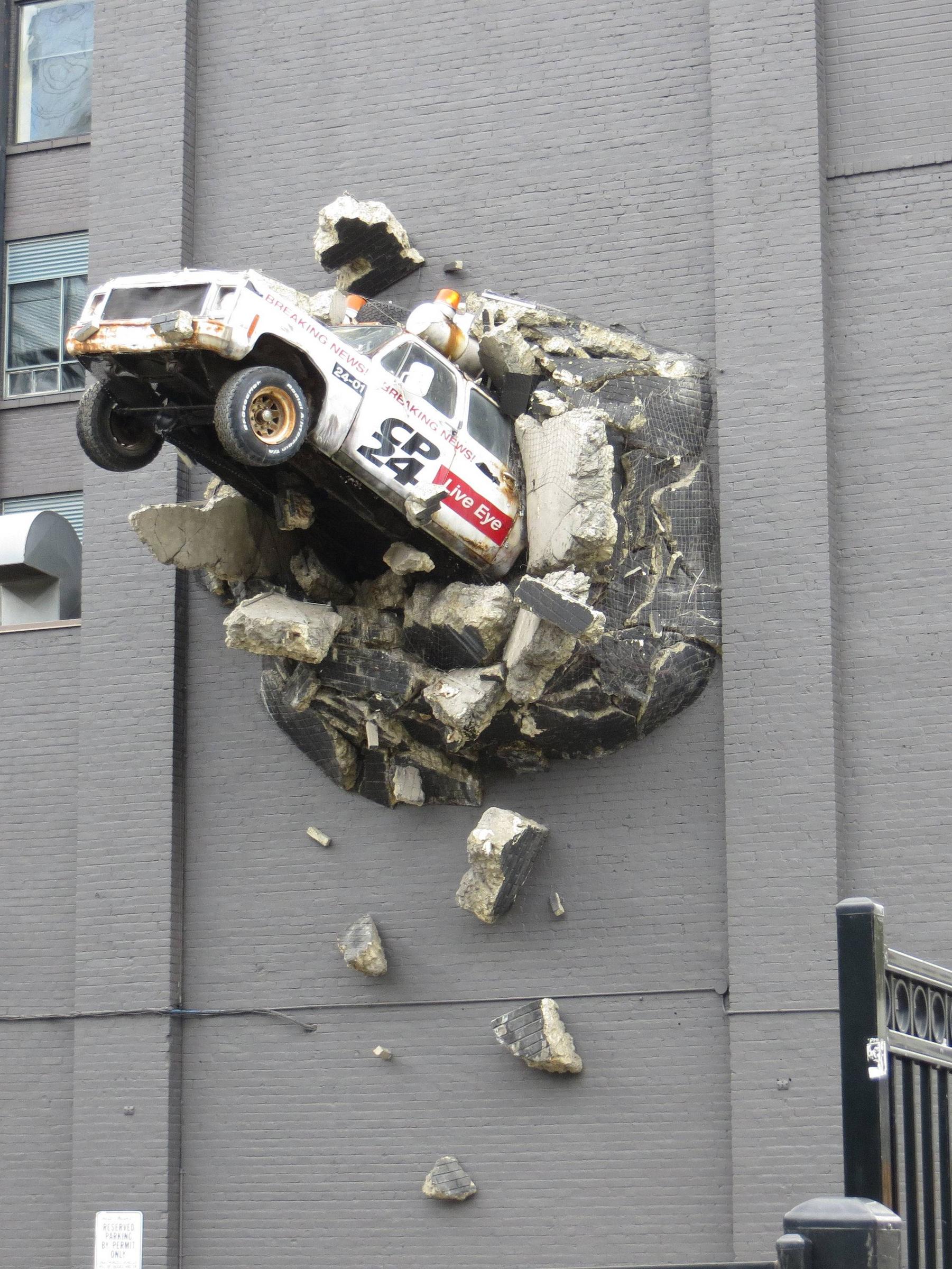 A car sticking out of a wall