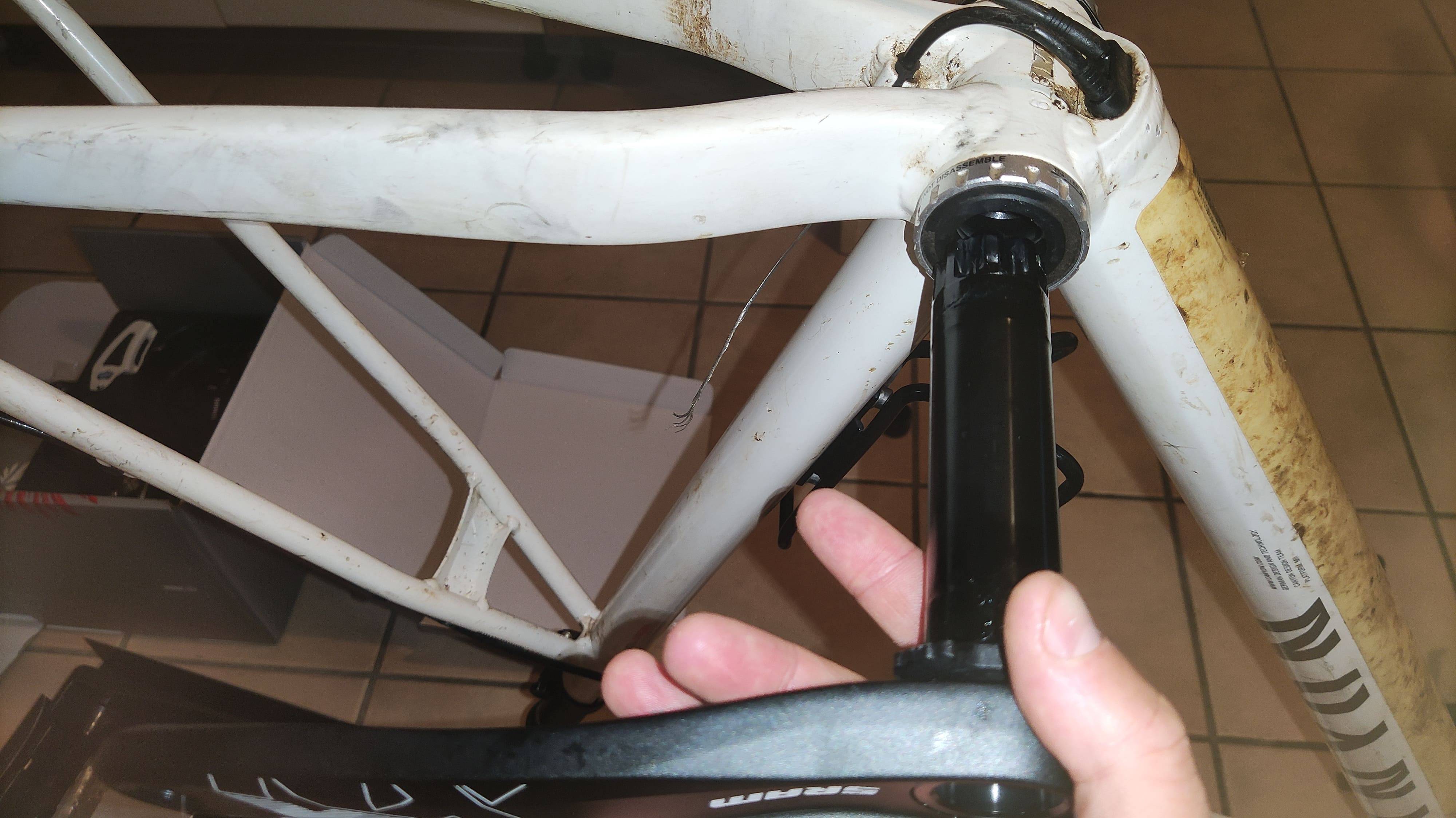 SRAM crank held beside Shimano bottom bracket, demonstrating lack of fit