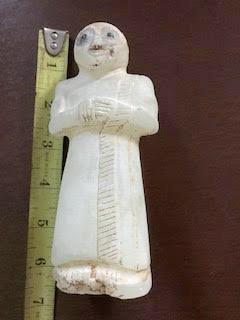 The statue next to a tape measure with US inches