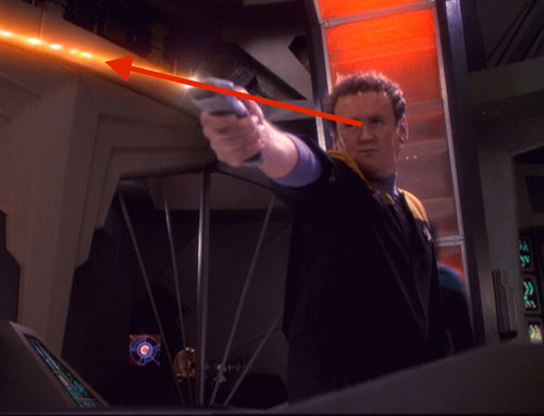 Chief Miles O'Brien firing a handheld phaser with a line drawn to indicate the direction and intent of his aim.