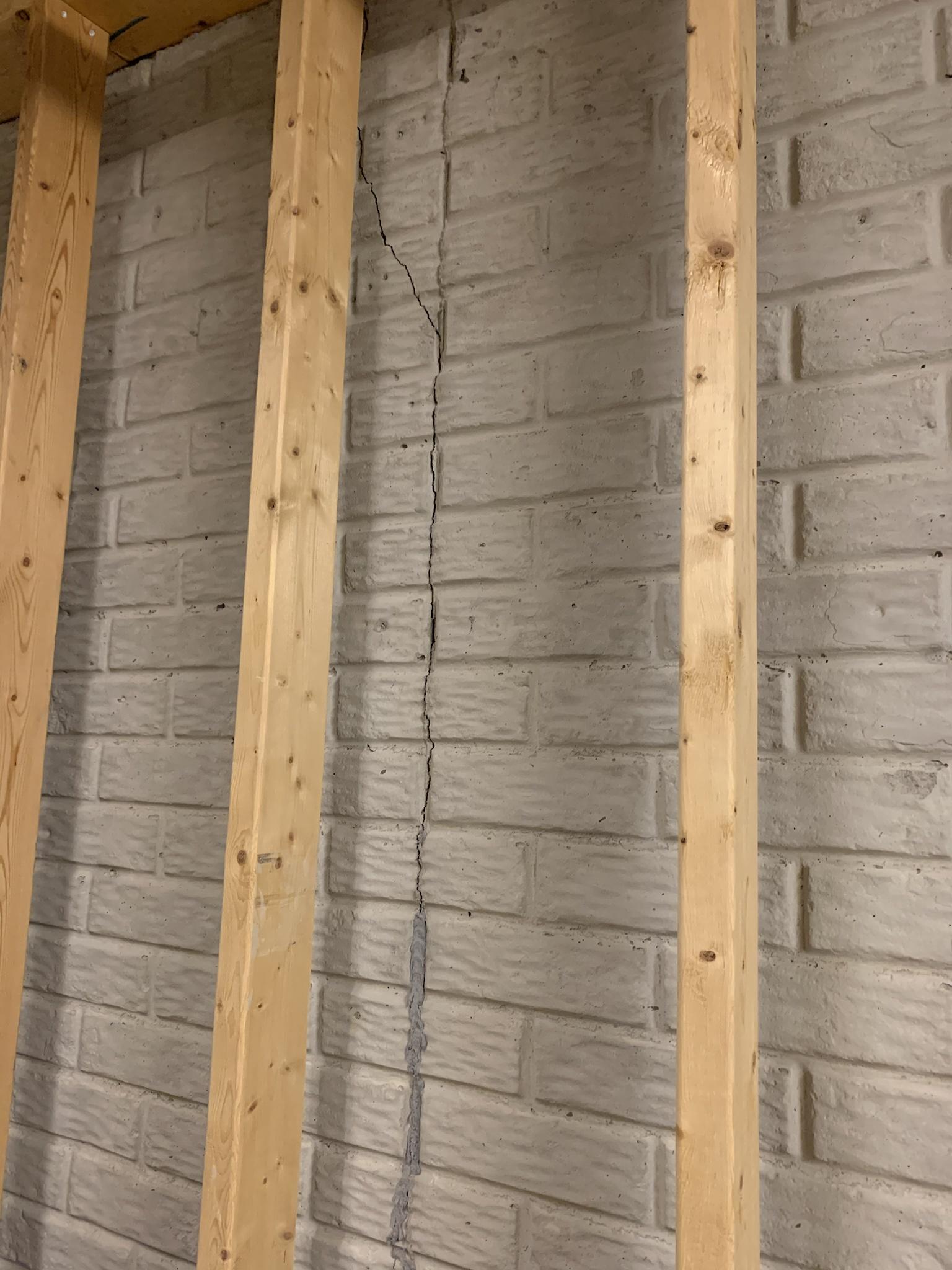 Section of wall showing completely vertical crack through brick