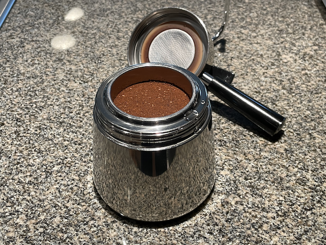 A stovetop coffee maker with a basket of coffee