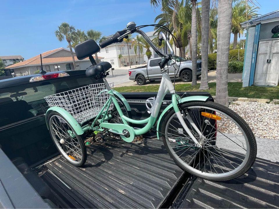 pale green tricycle in the bed of a pickup truck