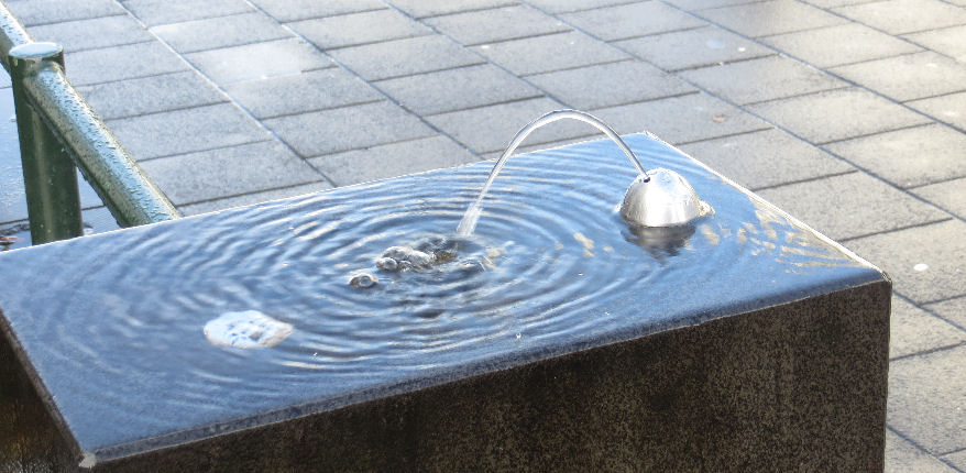 a bit of water on the top of a block of stone, with a water spout.