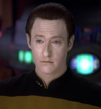 Screen cap of Brent Spiner as Data in his normal black and gold Starfleet uniform but with blue irises instead of yellow.