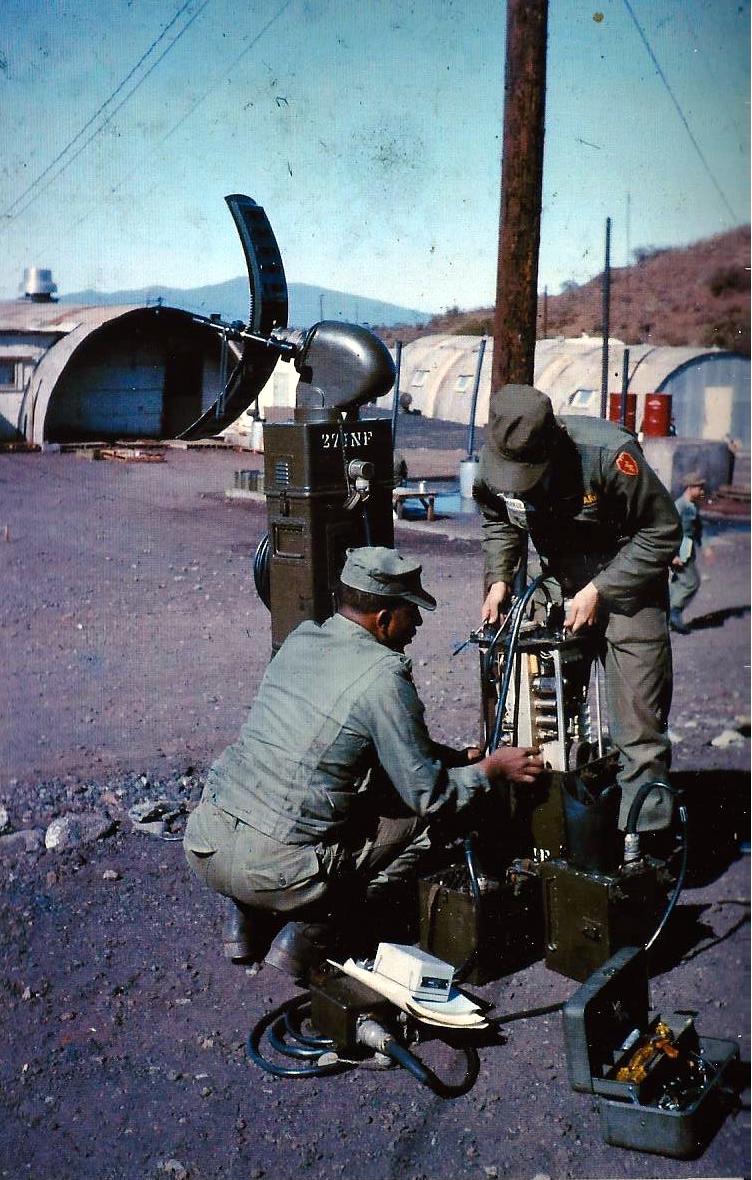 soldiers are wearing baseball caps servicing antennae