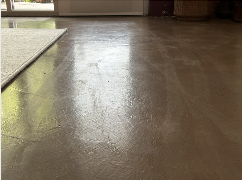 A photo of the concrete floor with long, matte streaks appearing where steam was applied