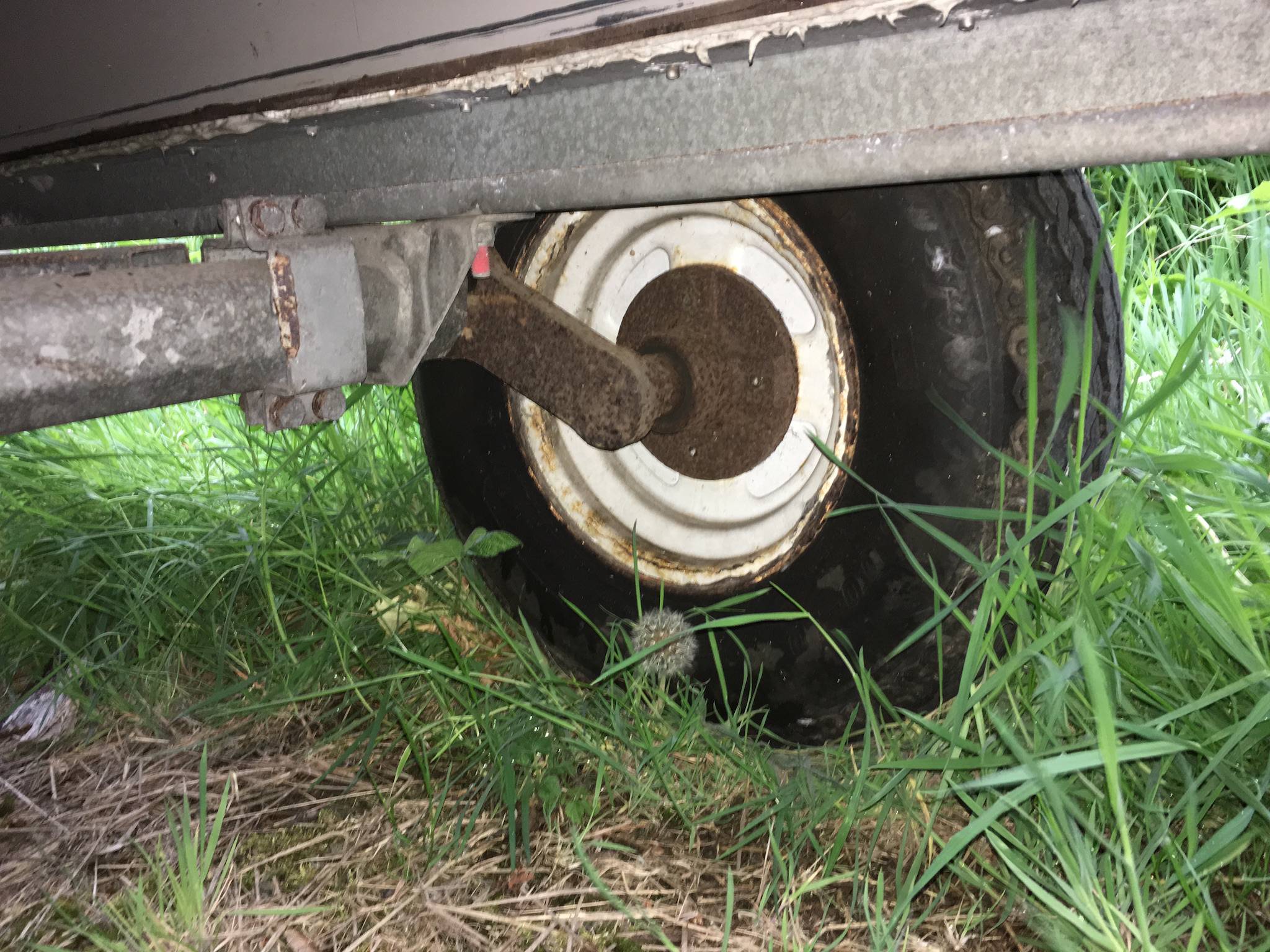 underside of trailer, showing wheel and rust