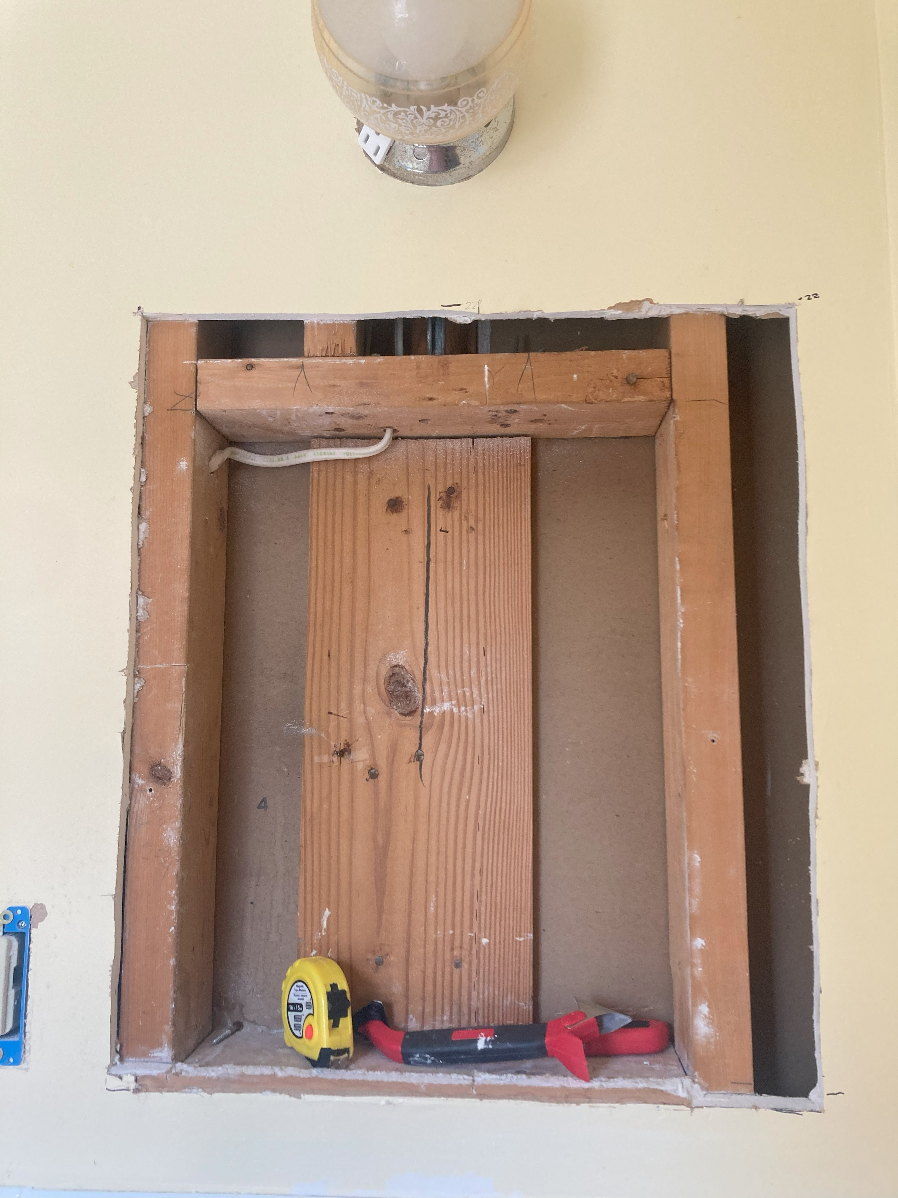 photo of wood framing in wall for previous medicine cabinet