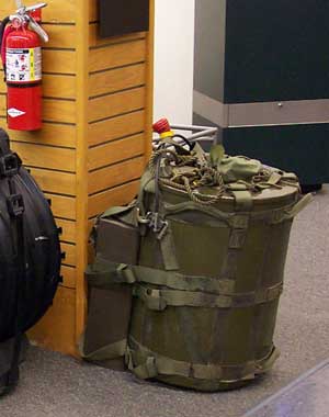 A backpack with a W54 nuke inside, propped against a column. A fire extinguisher is present for size comparison.