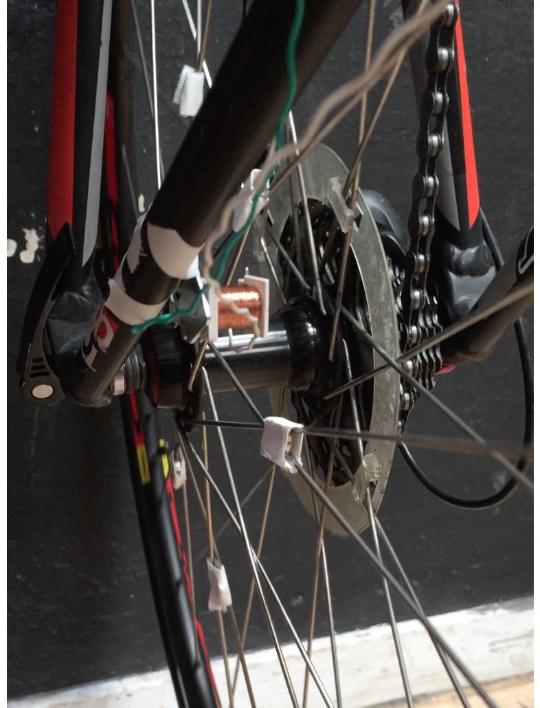 Coil attached to the rear fork with 6 magnets taped to the wheel spokes