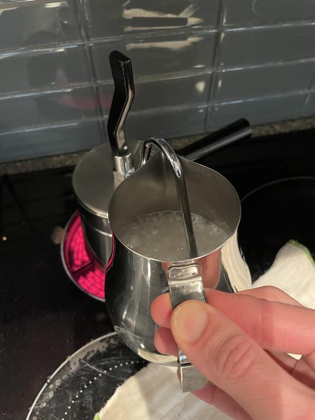 A stovetop coffee maker steaming some milk