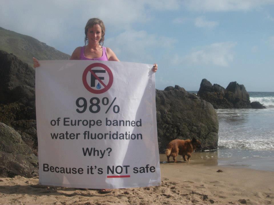 Woman with sign, 98% of Europe banned water fluoridation