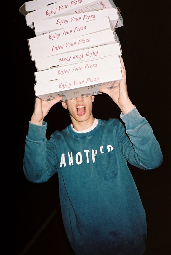 image of man with pizza boxes and black background