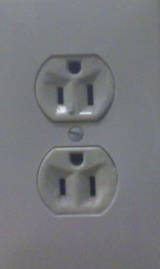 common electrical outlet (NEMA 5-15R duplex), ground hole on top