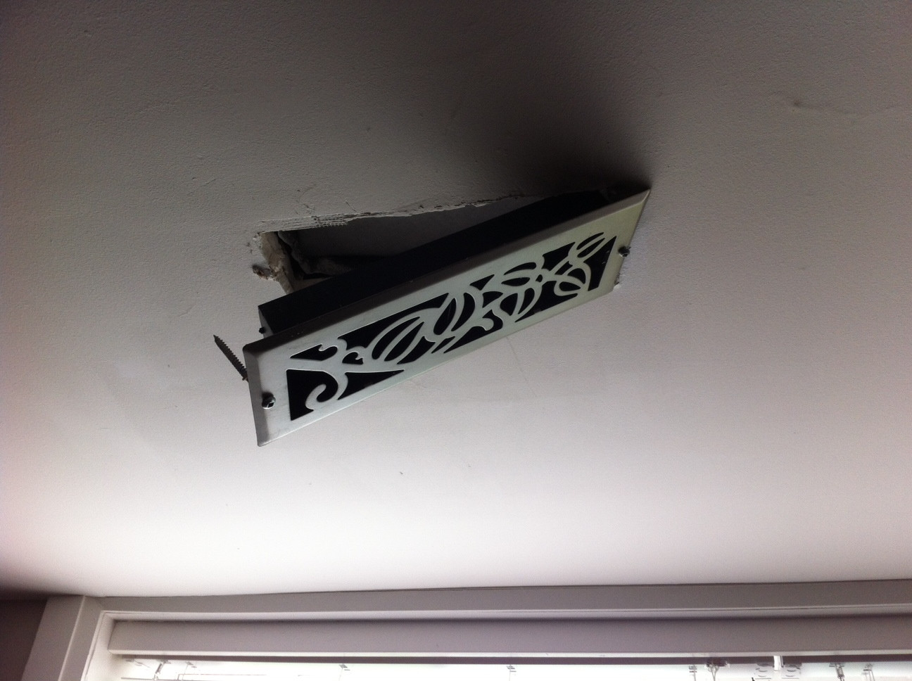 Vent hanging partway out from ceiling