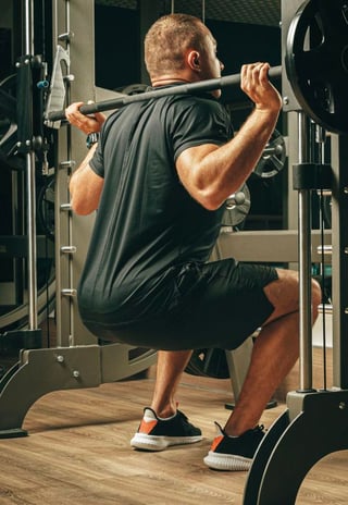 Image of a guy squatting in smith machine