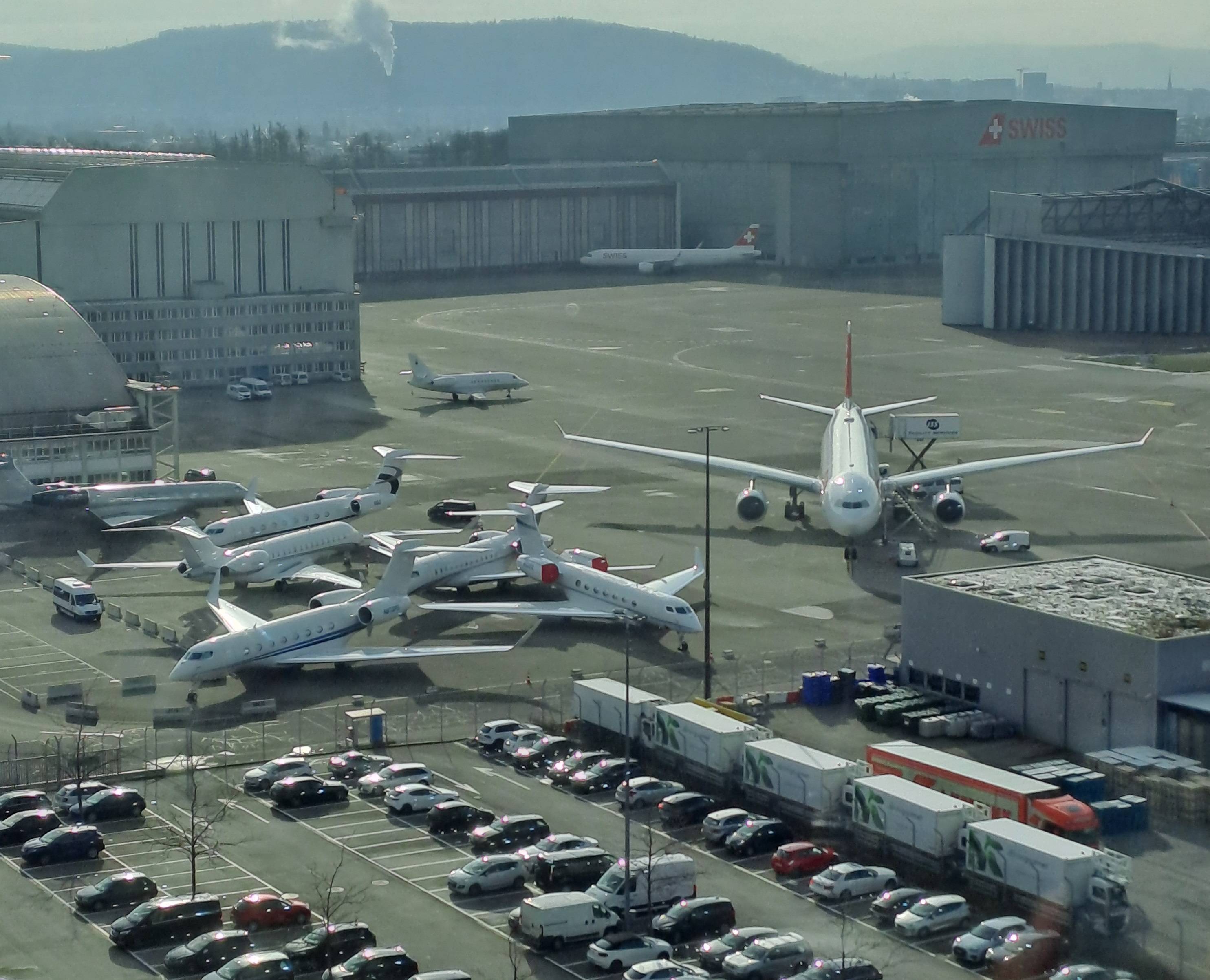 eight planes parked very closely together on an airport