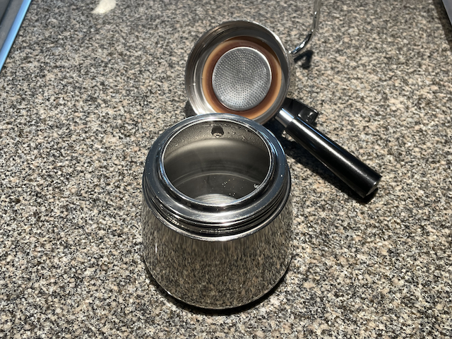 A stovetop coffee maker filled with boiling water