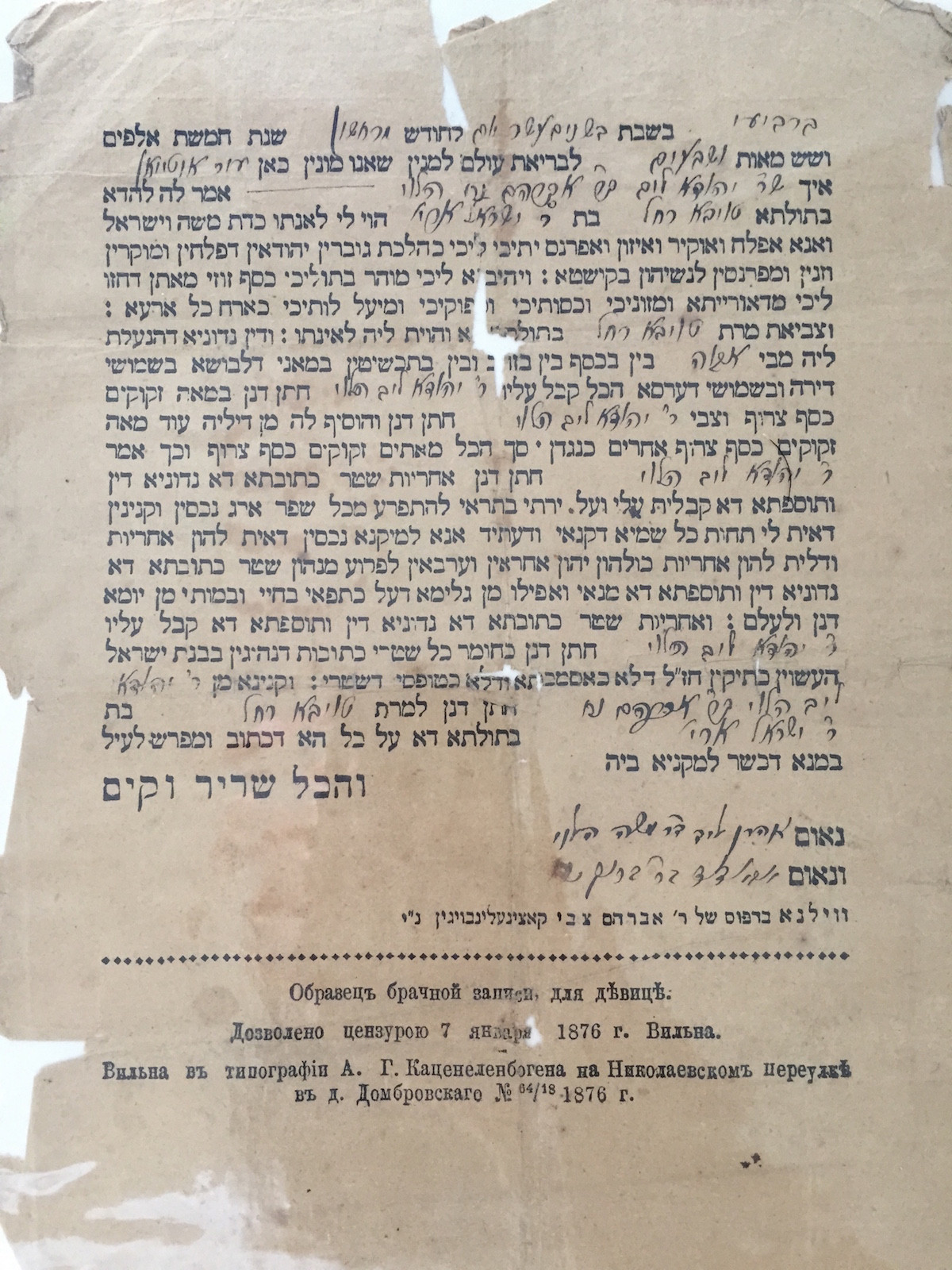 Yellowed, slightly tattered document consisting of a printed Hebrew form, with Hebrew script filled into certain spaces, and with Cyrillic printing at the bottom