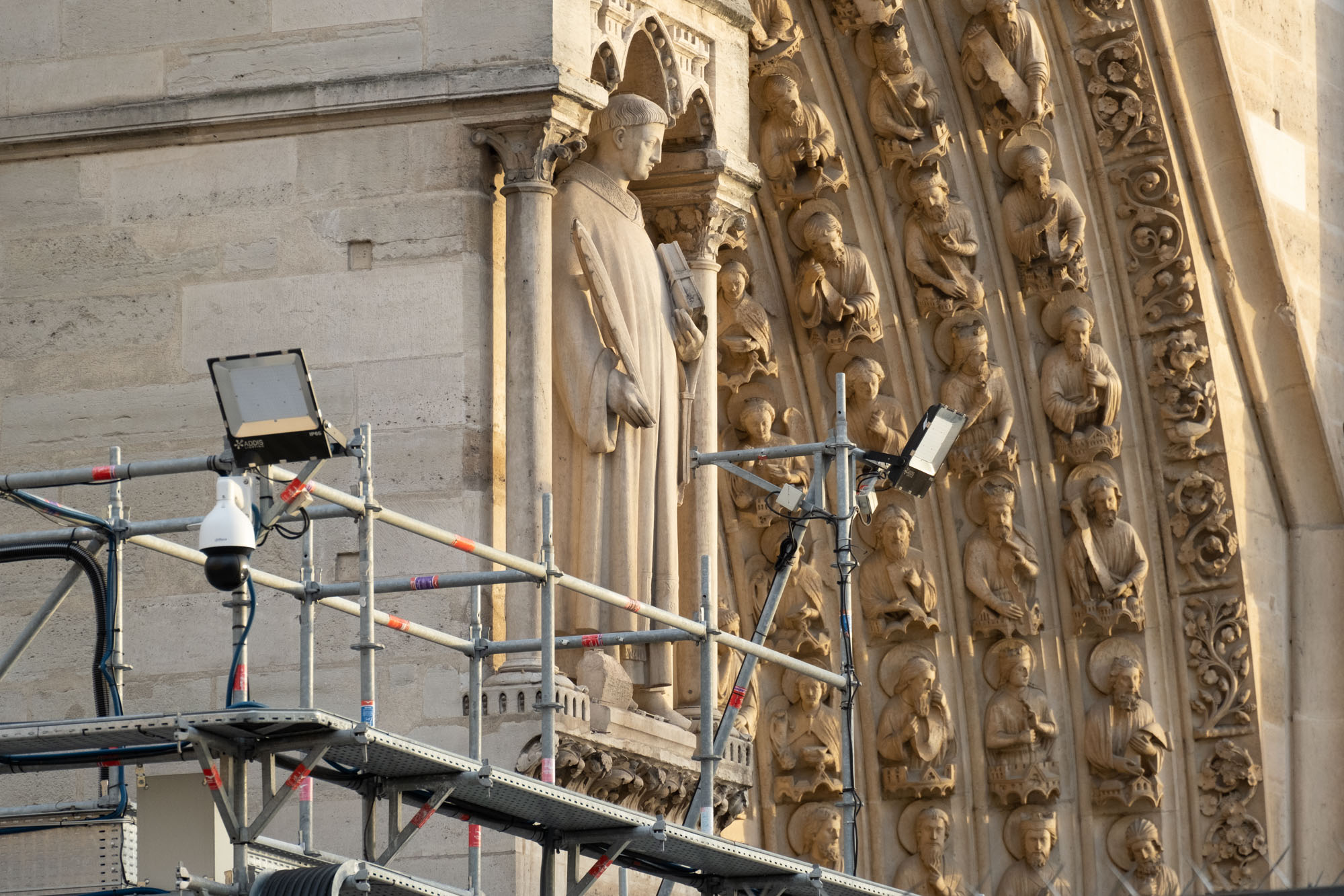 Statue of Saint Stephen on the west facade of Notre-Dame de Paris with scaffolding and security equipment