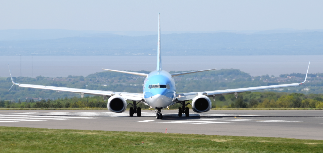 A commercial jet seen from the front, showing the significant dihedral angle to its wings.