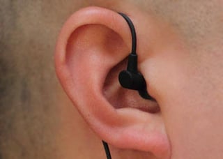 Earphone with cord passing over earlobe