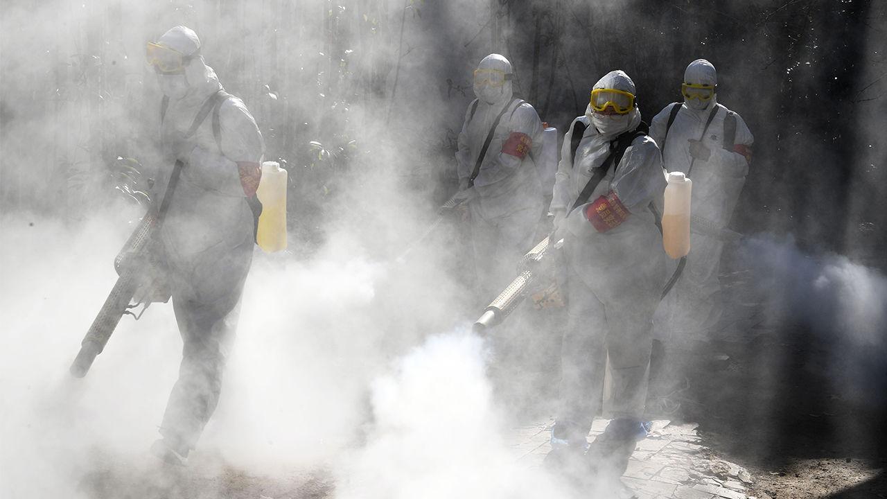 In Bozhou, China, in a photo from February, workers spray disinfectant to protect against the novel coronavirus.