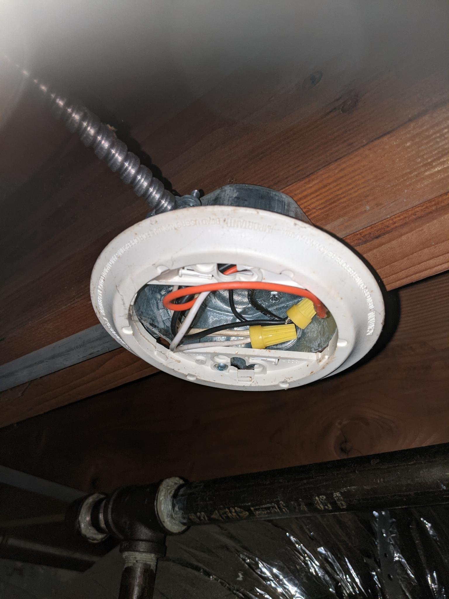 eviscerated ceiling fixture connected to two wire ducts