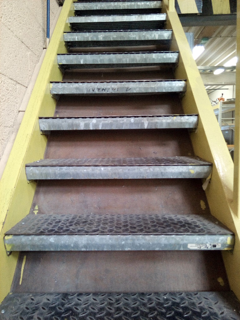 A metal staircase, seeing the front of the steps.