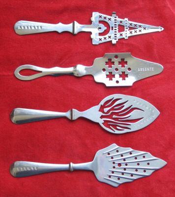 Collection of absinthe spoons. These are special spoons used to hold the sugar cube. Ice-cold water is poured over the sugar to dilute the absinthe. Note the slot on the handle that allows the spoon to rest safely on the brim of the glass.