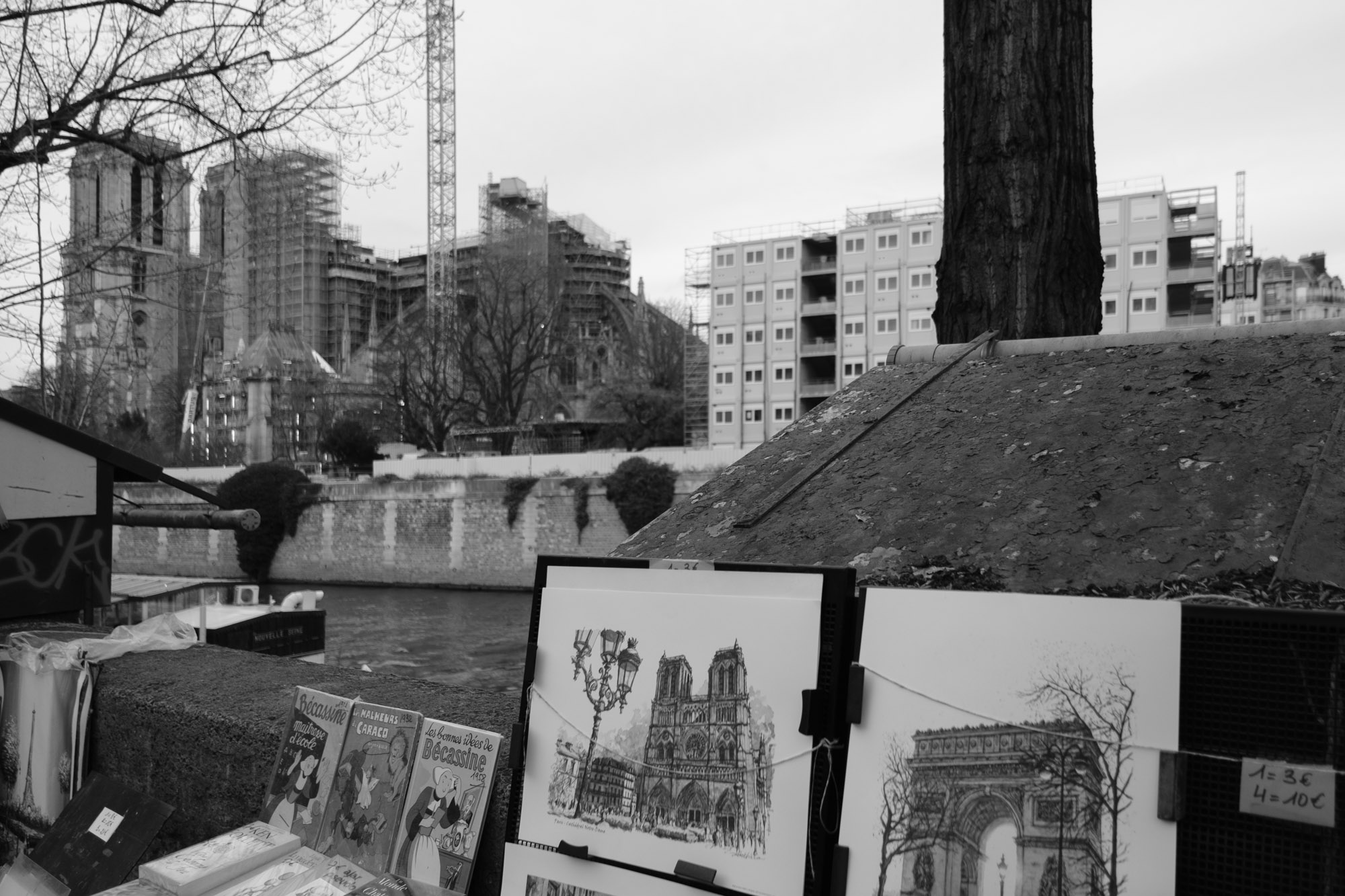 Notre-Dame enveloped in scaffolding behind a drawing of the church