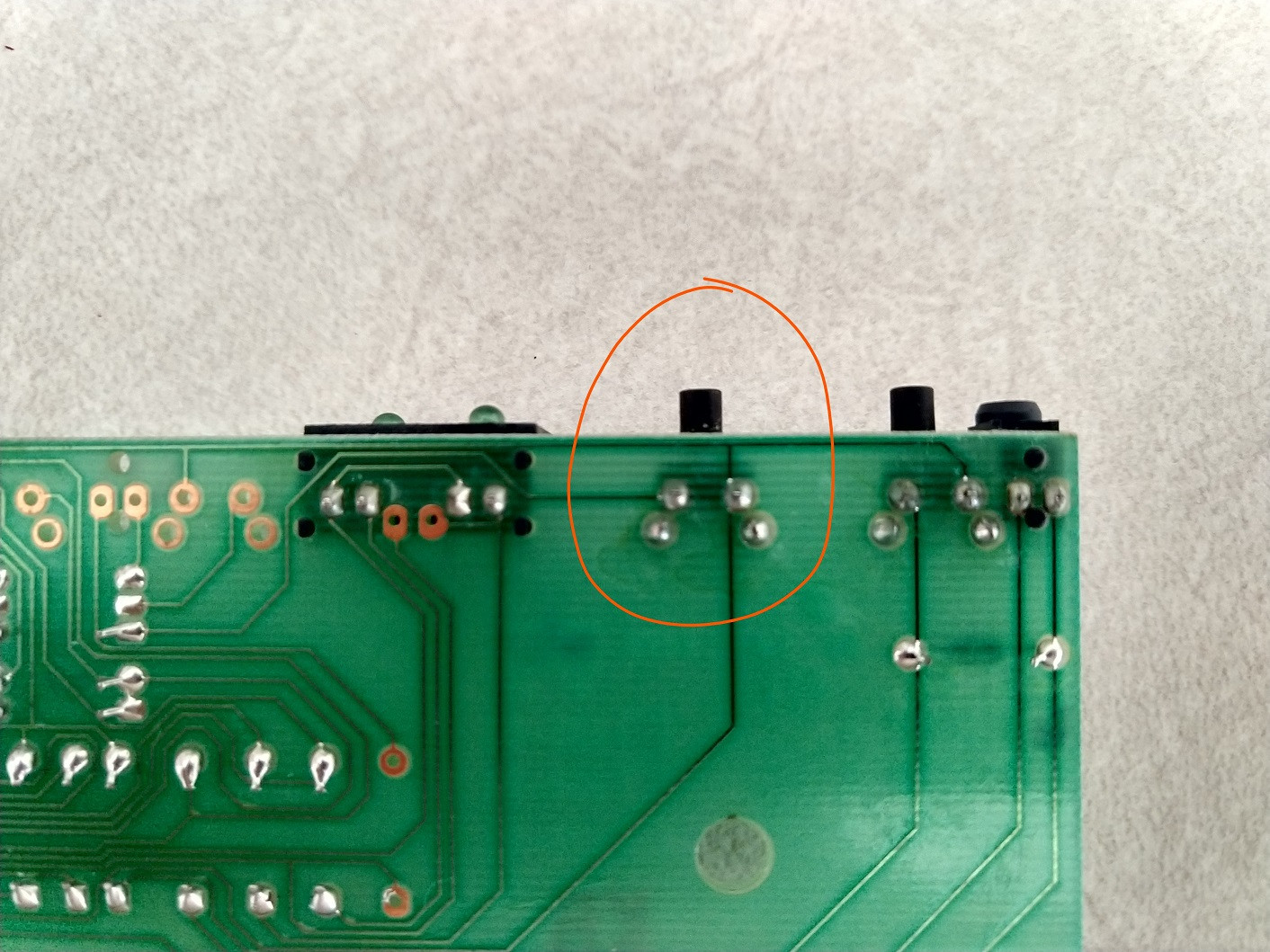 Control board from back with faulty switch circled in orange