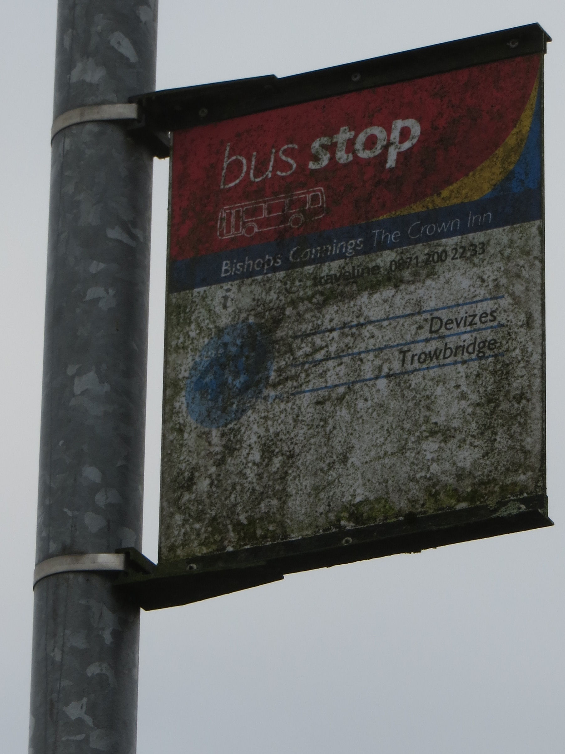 A bus stop sign which is quite dirty