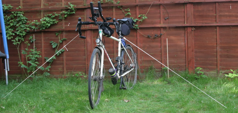 Touring bike held up by guy ropes