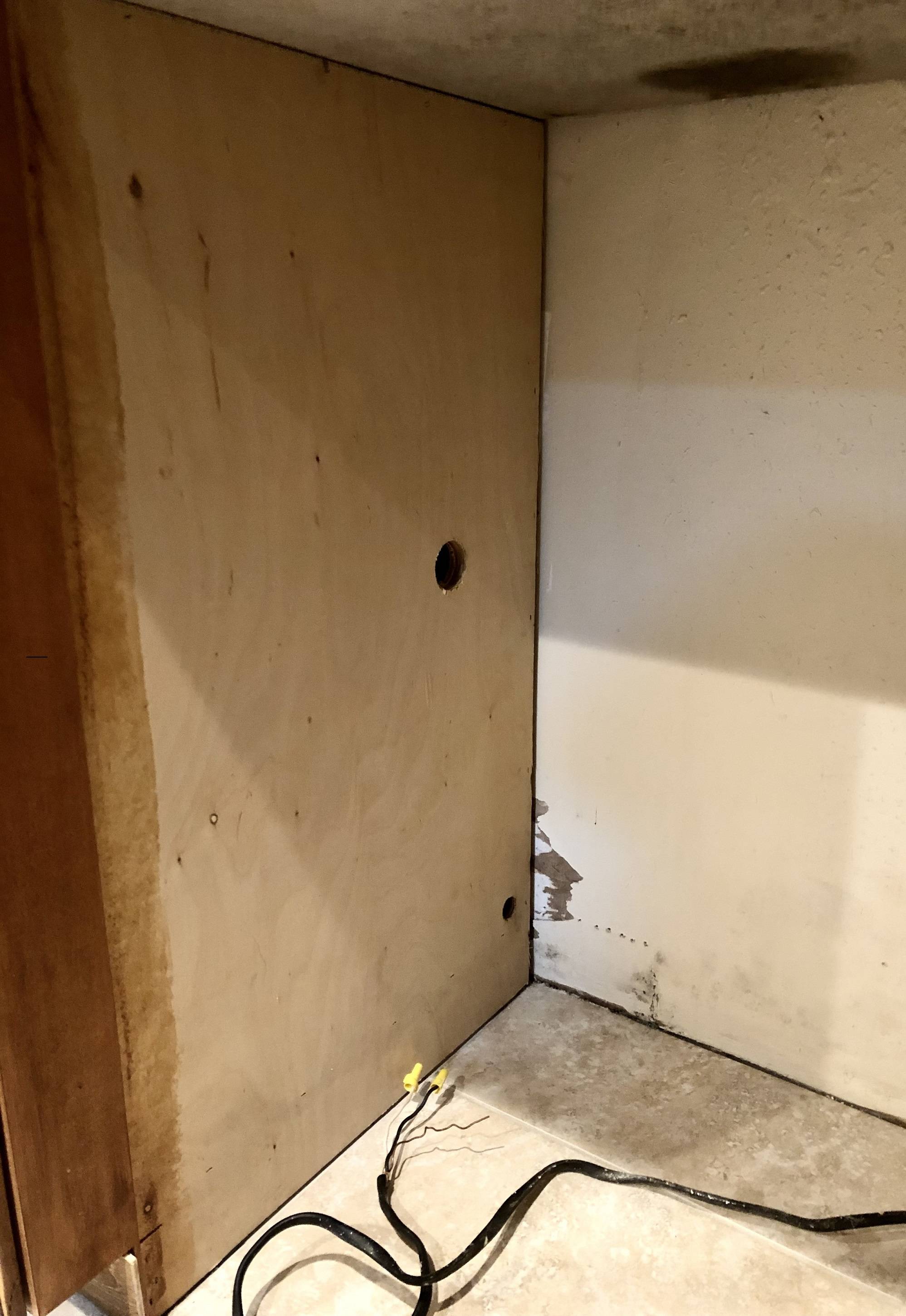 Space for dishwasher install, tile floor, granite top, playwood sides, dry wall on furred block