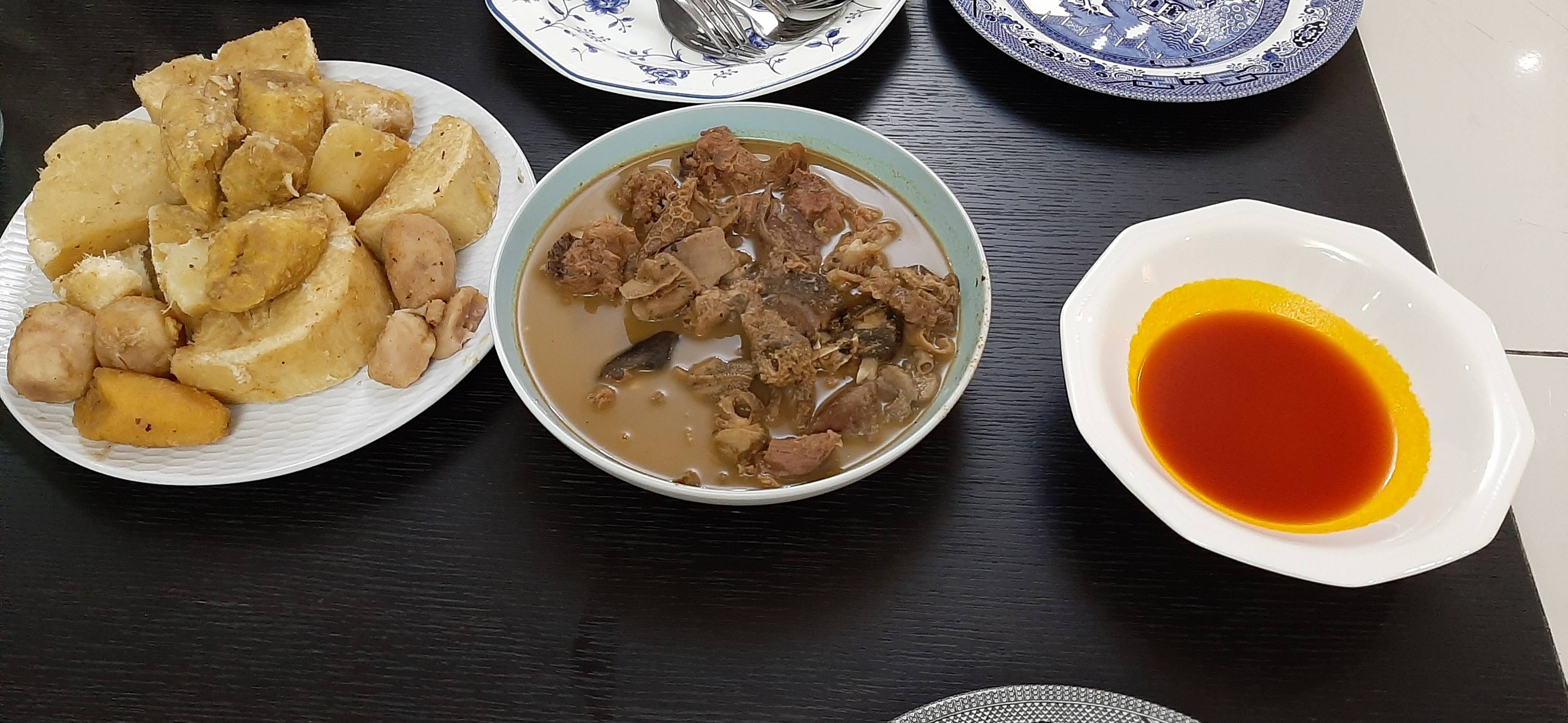 goat meat soup, boiled yam and plantain, palm oil